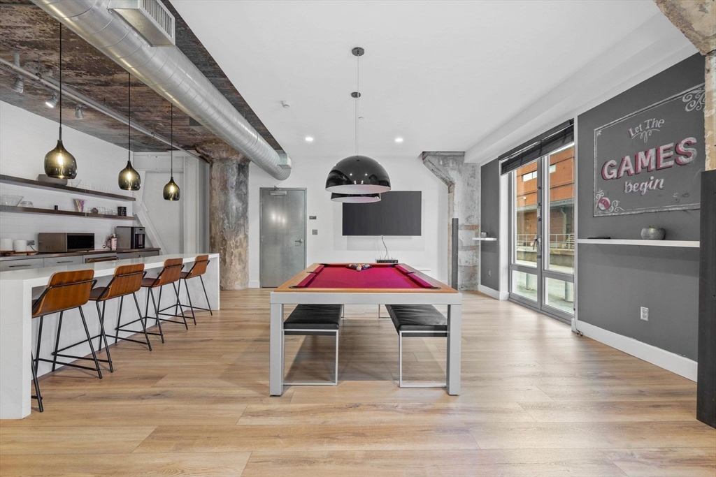 9 Medford Street, Unit PH3 Somerville, MA 02143 - Photo 24 of 30 a room with furniture and wooden floor