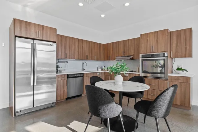 a kitchen with a refrigerator and table chairs