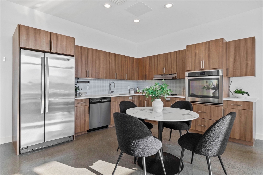 9 Medford Street, Unit PH3 Somerville, MA 02143 - Photo 6 of 30 a kitchen with a refrigerator and table chairs