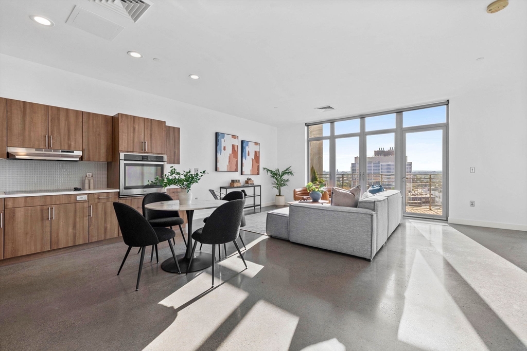 9 Medford Street, Unit PH3 Somerville, MA 02143 - Photo 7 of 30 a living room with furniture and a dining table with kitchen view