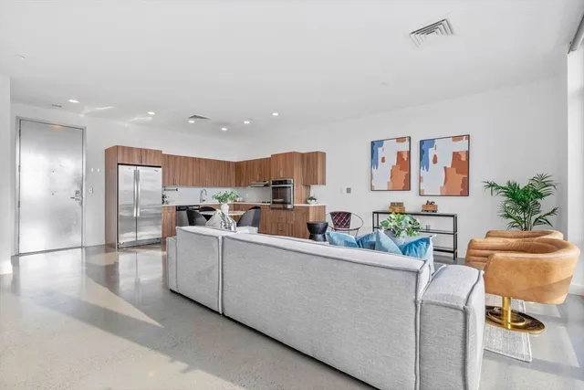 a living room with furniture and a dining table with kitchen view
