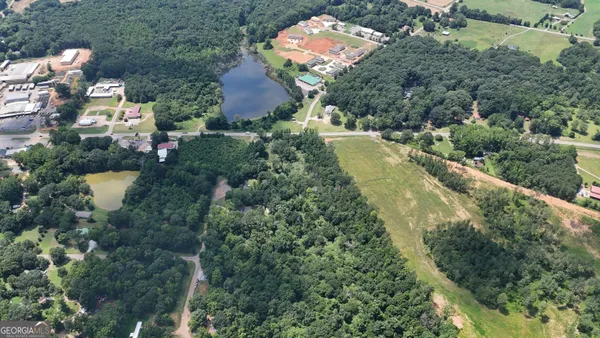 an aerial view of residential house with outdoor space and trees all around