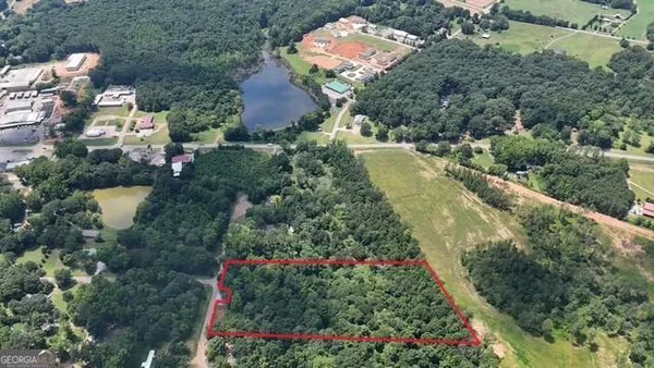 an aerial view of residential house with outdoor space and trees all around