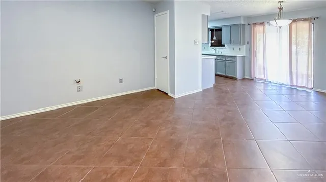 a view of kitchen with granite countertop cabinets and refrigerator