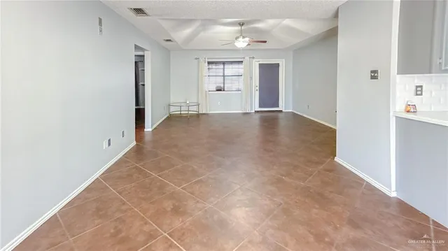 an empty room with windows and chandelier