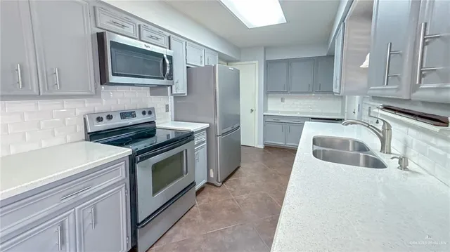 a kitchen with stainless steel appliances a stove sink microwave and cabinets