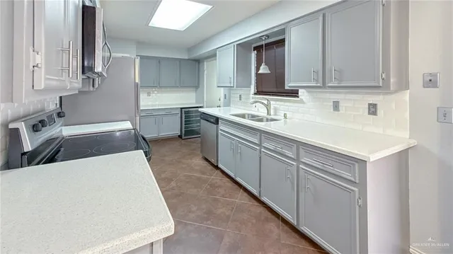 a kitchen with stainless steel appliances a sink stove and cabinets