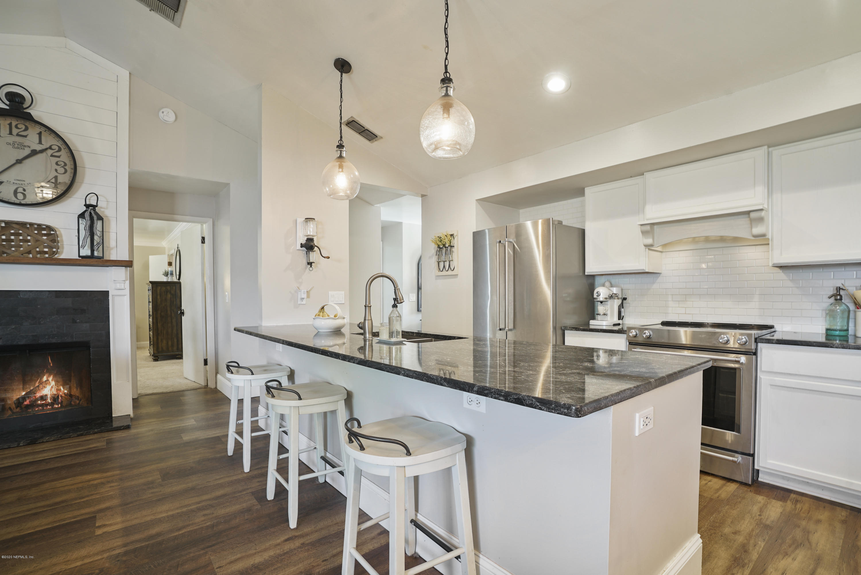 2465 Wattle Tree Road West Jacksonville, FL 32246 - Photo 4 of 31 a kitchen with stainless steel appliances granite countertop a stove top oven a sink a dining table and chairs with wooden floor