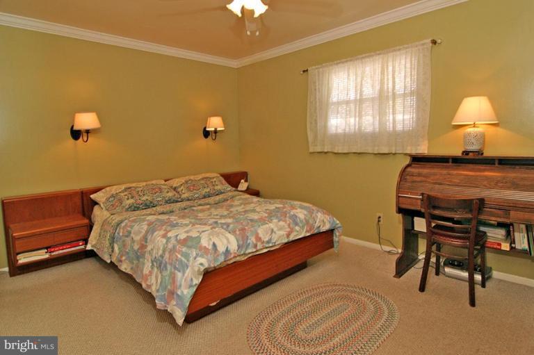 3915 Setonhurst Road Pikesville, MD 21208 - Photo 10 of 17 a bedroom with a bed table chair and a window