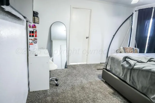 a spacious bedroom with a bed and a chandelier