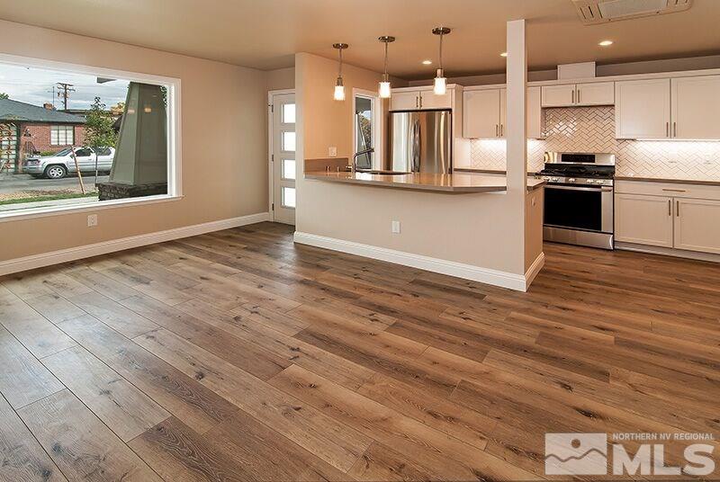 74 Caliente Street Reno, NV 89509 - Photo 3 of 13 a large kitchen with stainless steel appliances granite countertop a stove and a wooden floors
