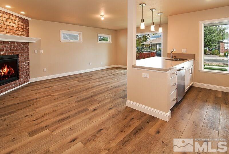 74 Caliente Street Reno, NV 89509 - Photo 4 of 13 a room with kitchen island a wooden floor and a fireplace
