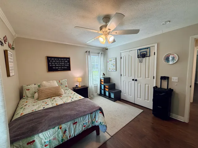 a spacious bedroom with a bed and a flat screen tv