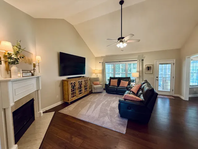 a living room with furniture a flat screen tv and a fireplace