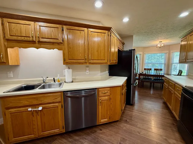 a kitchen with stainless steel appliances granite countertop a sink a stove and a refrigerator