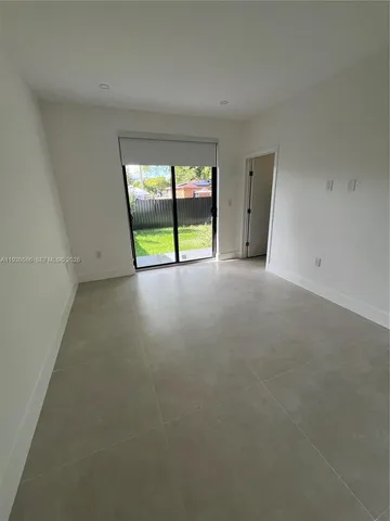 a view of an empty room with a floor to ceiling window