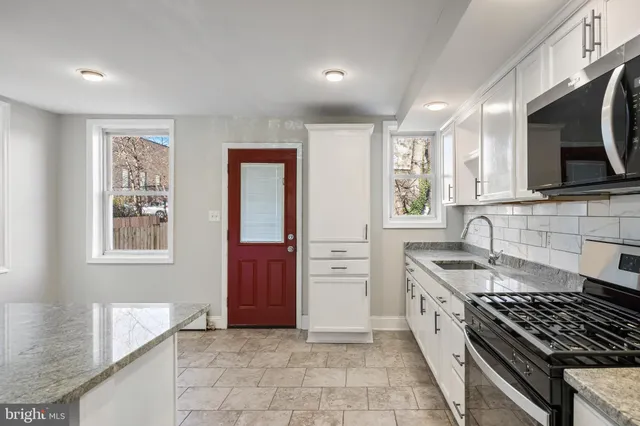 a kitchen with stainless steel appliances granite countertop a sink stove and cabinets