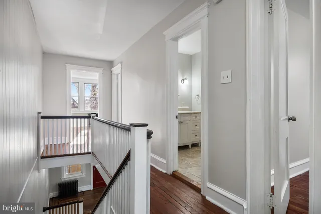 a view of a hallway with entryway and wooden floor