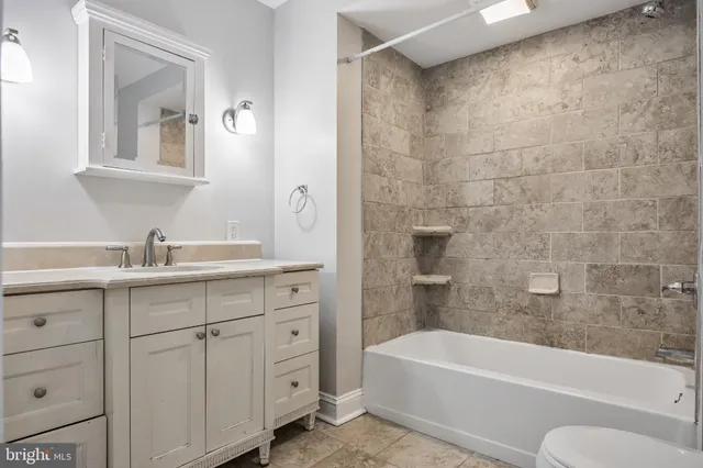 a bathroom with a tub a sink and a mirror