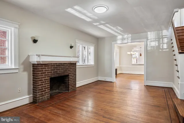a view of an empty room with glass door and wooden floor