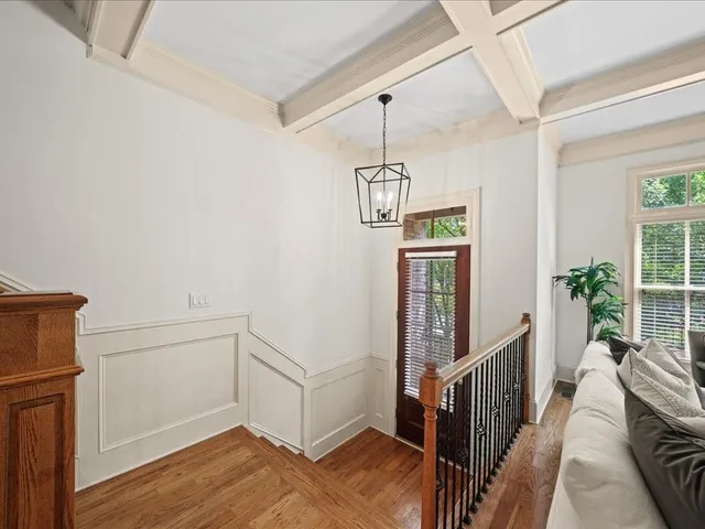 a view of a hallway with wooden floor and staircase
