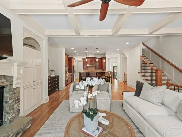 a living room with furniture kitchen view and a flat screen tv