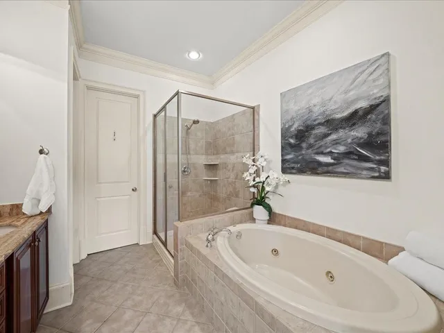 a spacious bathroom with a tub sink and mirror