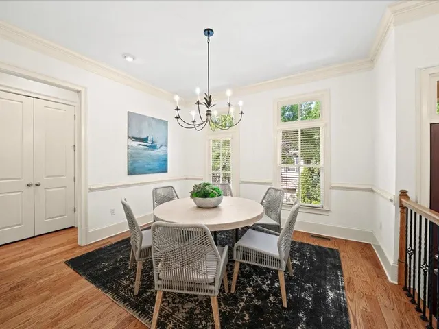 a view of a dining room with furniture a chandelier and wooden floor
