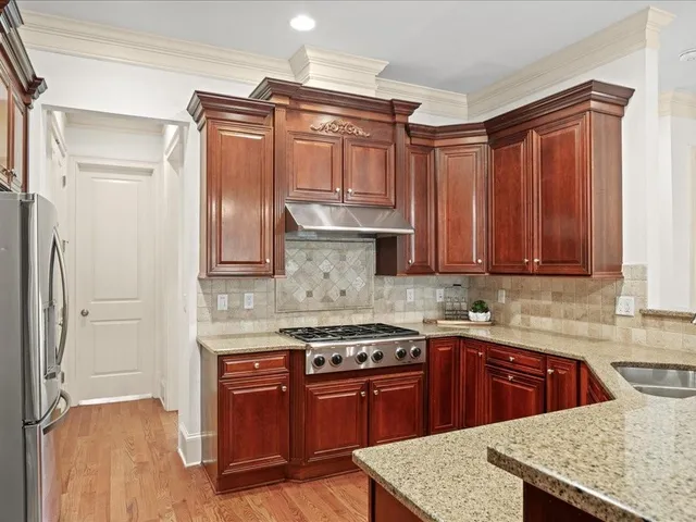a kitchen with stainless steel appliances granite countertop a sink stove and refrigerator