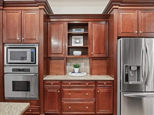 a kitchen with stainless steel appliances granite countertop a refrigerator and a microwave