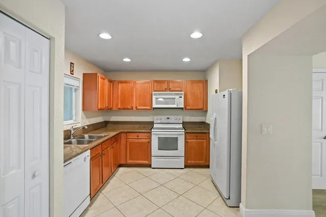 a kitchen with stainless steel appliances granite countertop a stove a sink and a refrigerator