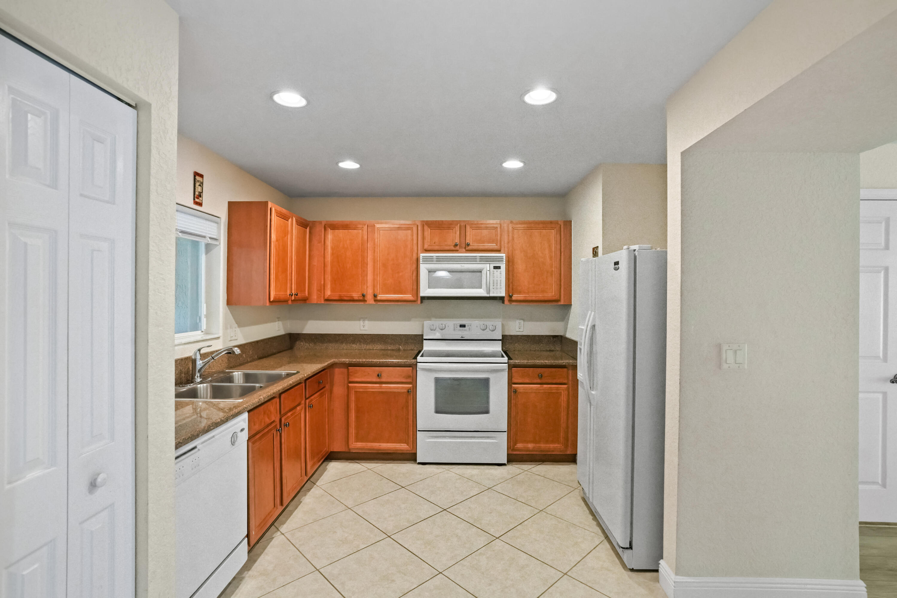 5961 London Lane Tamarac, FL 33321 - Photo 5 of 21 a kitchen with stainless steel appliances granite countertop a stove a sink and a refrigerator