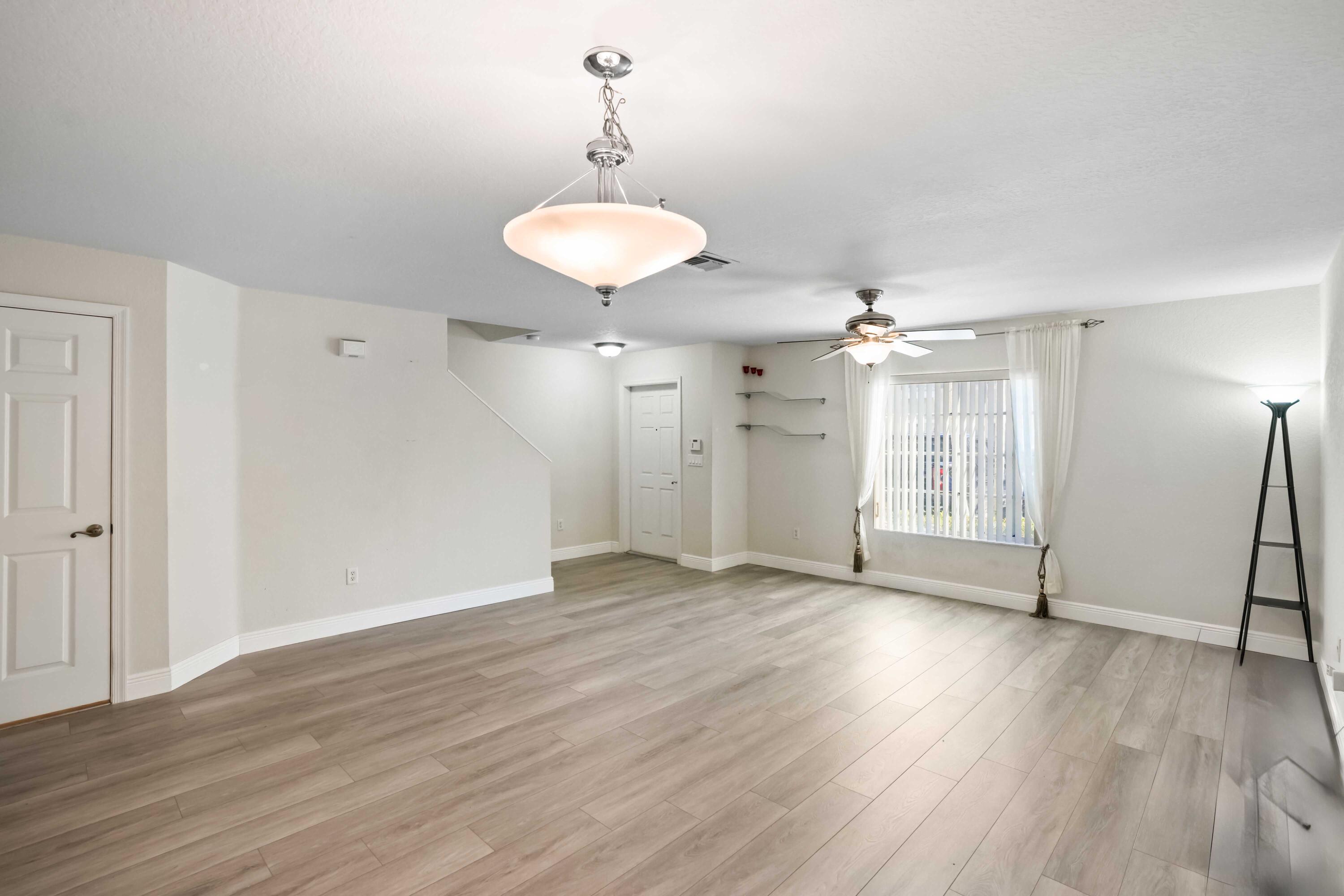 5961 London Lane Tamarac, FL 33321 - Photo 8 of 21 a view of a room with wooden floor and chandelier