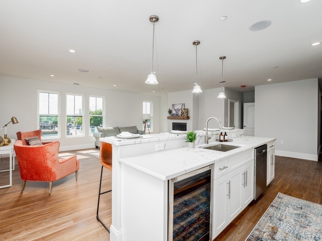 a large kitchen with kitchen island a island a sink a stove and a large window
