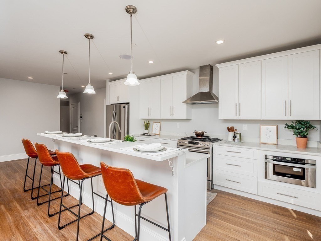 45 L Street, Unit 20 Boston, MA 02127 - Photo 11 of 28 a kitchen with stainless steel appliances kitchen island a stove a sink and a refrigerator