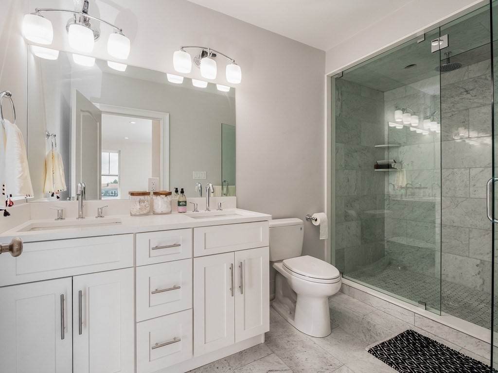 45 L Street, Unit 20 Boston, MA 02127 - Photo 24 of 28 a bathroom with a double vanity sink mirror and toilet