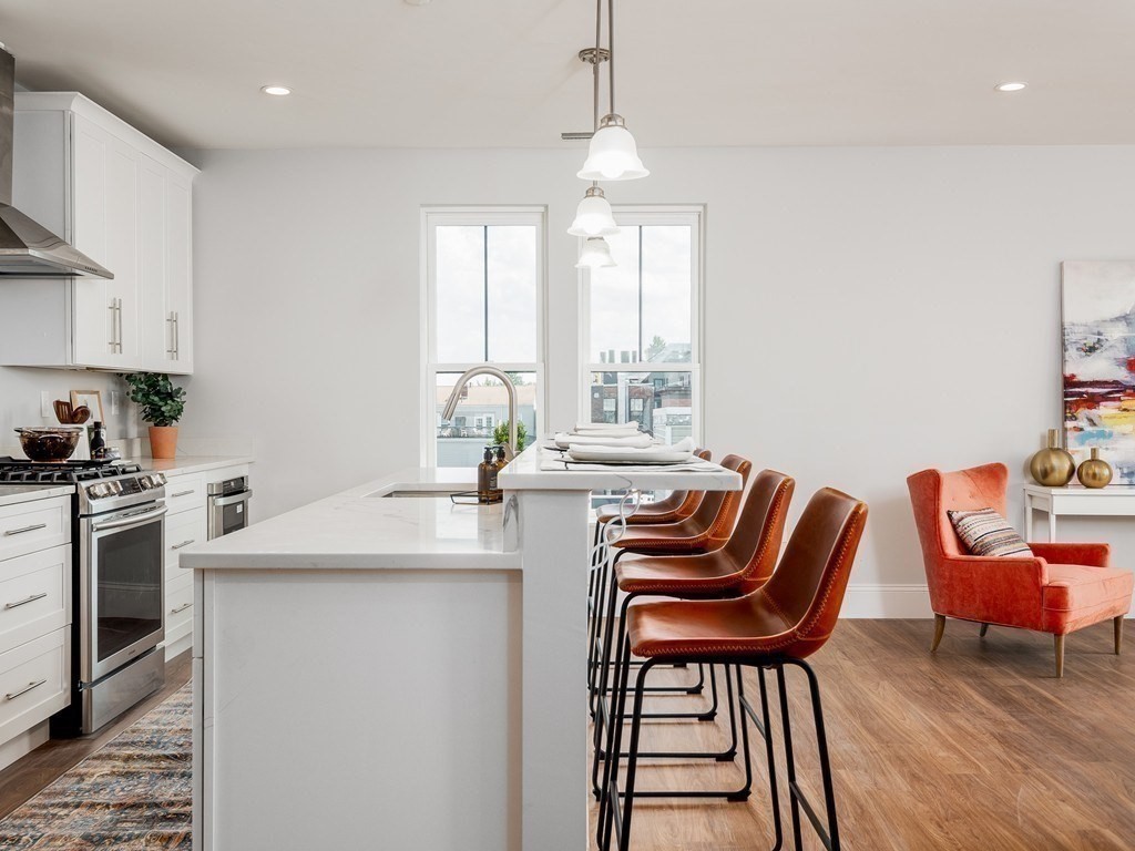 45 L Street, Unit 20 Boston, MA 02127 - Photo 9 of 28 a kitchen with stainless steel appliances granite countertop a table chairs in it and a window
