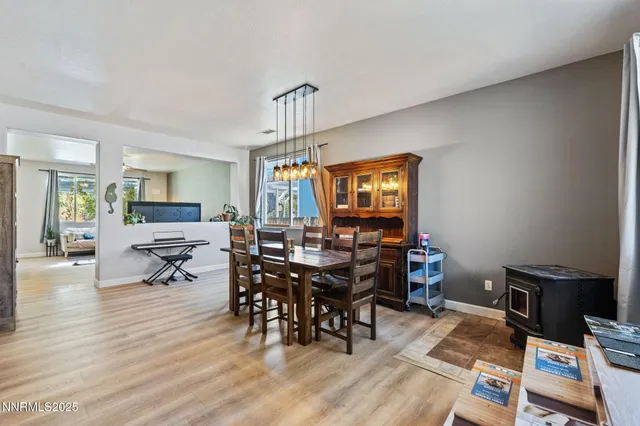 a living room with furniture and a dining table with wooden floor