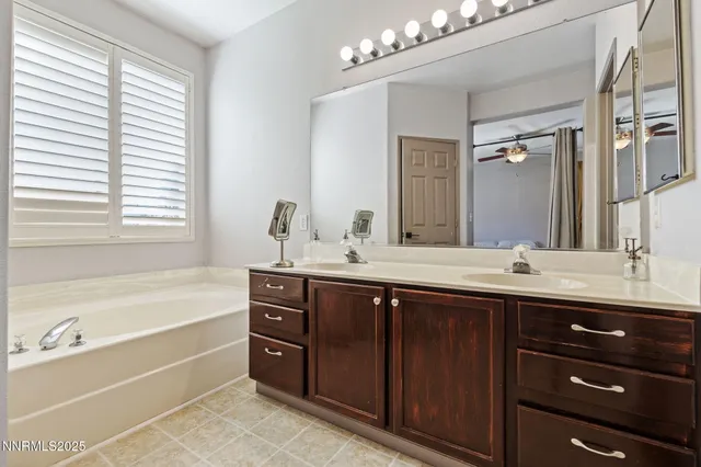 a bathroom with a tub double sink and mirror