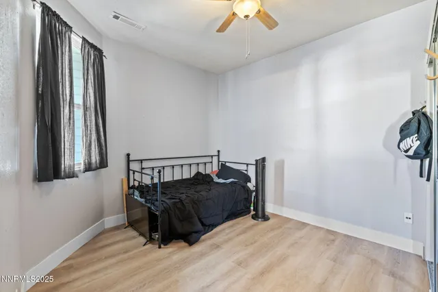 a bed sitting in a bedroom next to a window and a chandelier