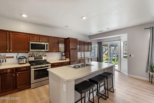 a kitchen with a sink a stove and chairs