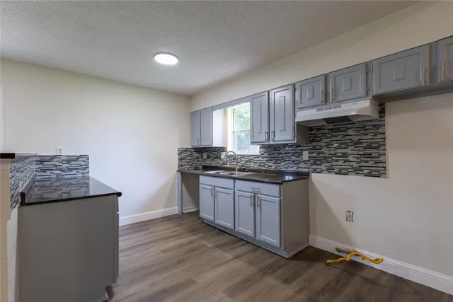 a kitchen with granite countertop wooden cabinets and white appliances
