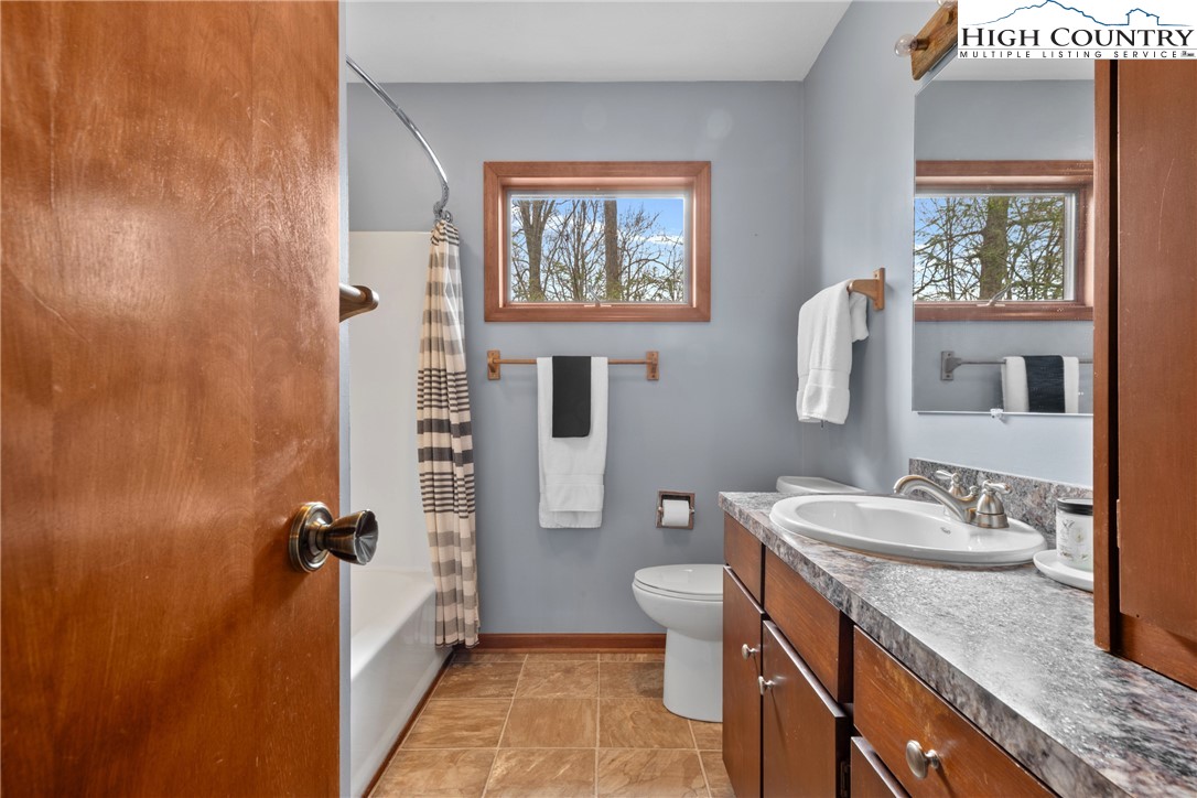 255 River Hollow Road Newland, NC 28657 - Photo 14 of 30 a bathroom with a granite countertop sink toilet and shower
