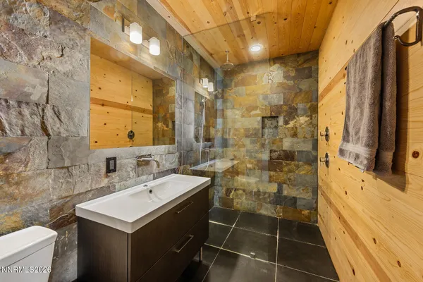 a bathroom with a sink a toilet and shower