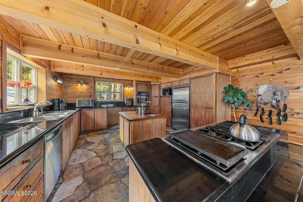 a kitchen with stainless steel appliances granite countertop a sink and a refrigerator