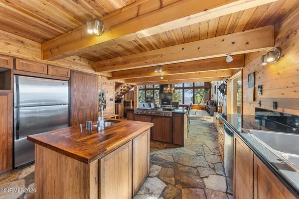 a kitchen with stainless steel appliances granite countertop a sink and a refrigerator