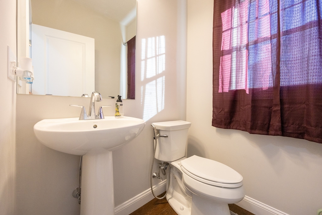 1 Clover Drive Bellingham, MA 02019 - Photo 15 of 34 a bathroom with a sink a toilet and shower curtain