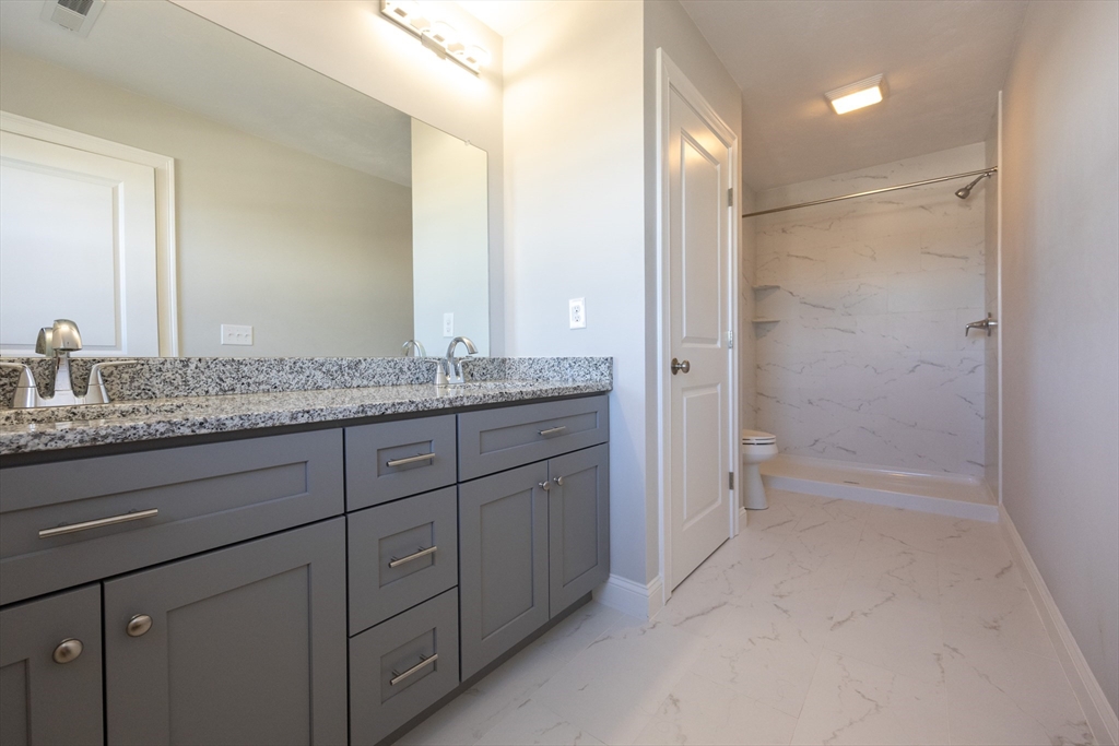 1 Clover Drive Bellingham, MA 02019 - Photo 19 of 34 a bathroom with a granite countertop sink two mirror and a shower