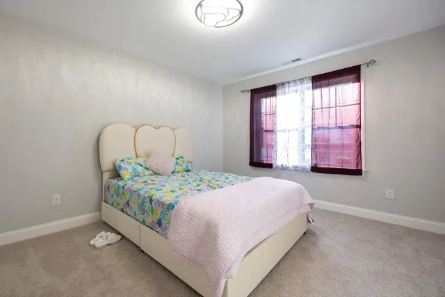 a bedroom with a bed table and window