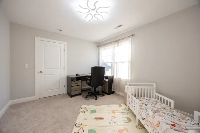a view of a bedroom with workspace and windows